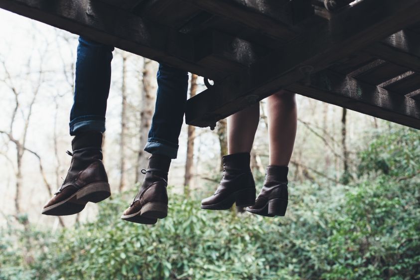 couple sitting on swinging bridge